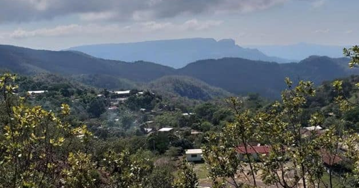 Vista de un paisaje montañoso con valles, colinas y casas dispersas bajo un cielo nublado en la sierra del Rosario.