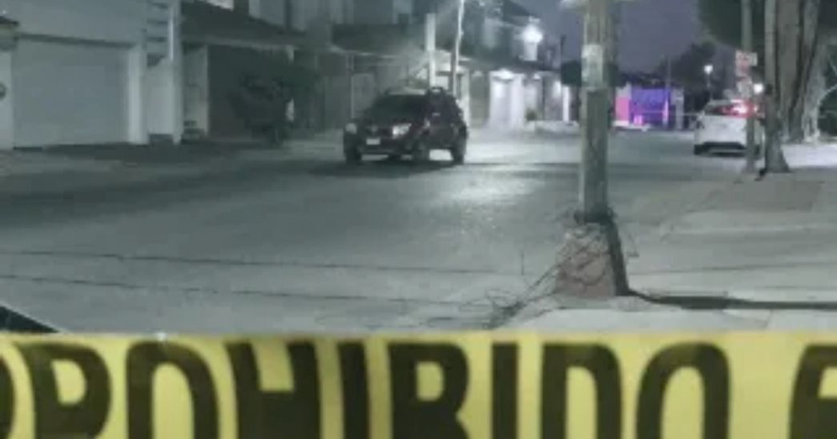Calle nocturna con cinta de advertencia y vehículo en Culiacán