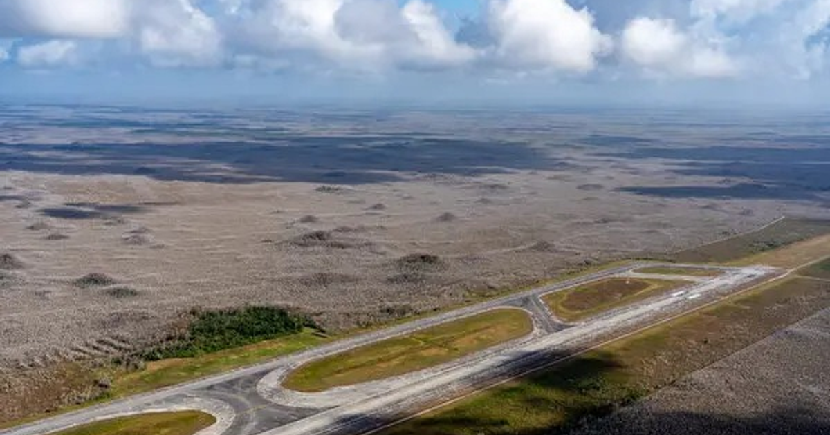 Vista aérea del paisaje en los Everglades con pista de aterrizaje y áreas verdes.