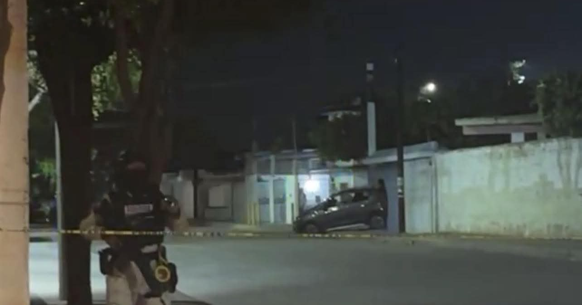 Oficial de seguridad junto a cinta amarilla en escena nocturna de Culiacán