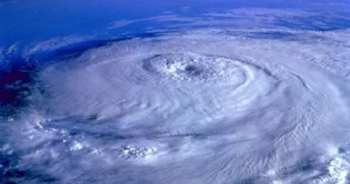 Huracán visto desde arriba con nubes en espiral y ojo central sobre el océano
