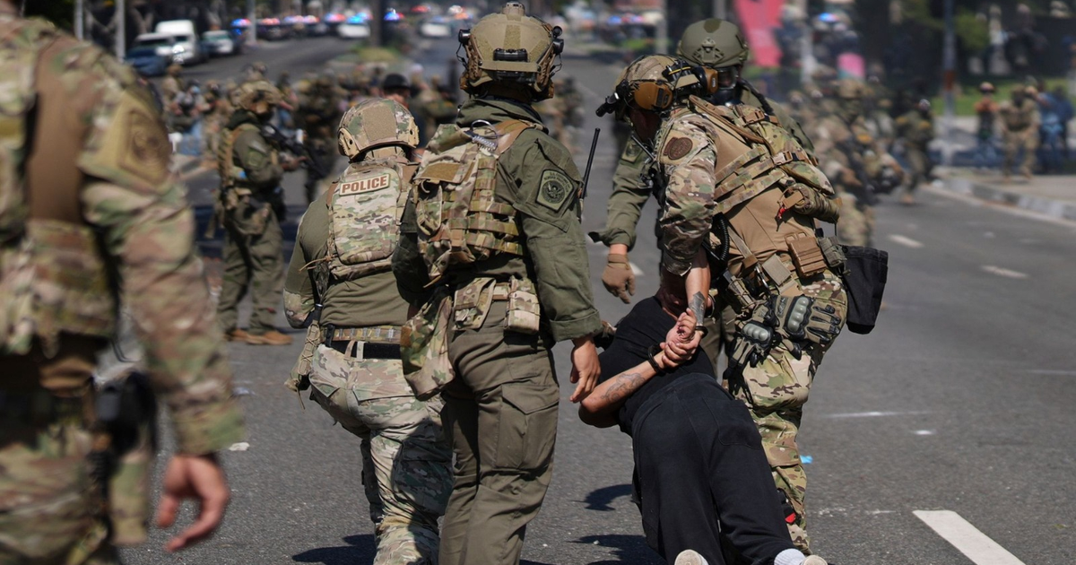 Agentes de seguridad detienen a una persona en Los Ángeles durante protestas.