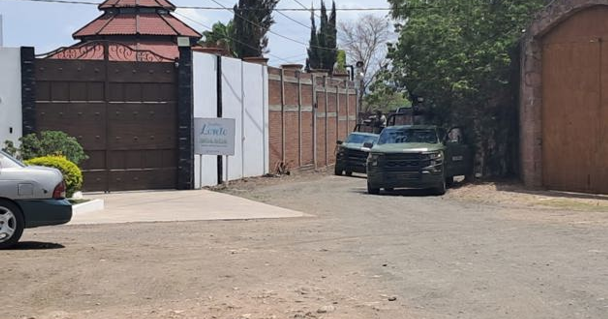 Portón de madera y vehículos en acceso a propiedad en Culiacán