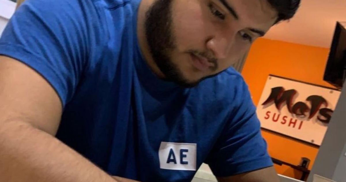 Persona concentrada con letrero de Sushi en el fondo, relacionada con caso de desaparición en Sinaloa.