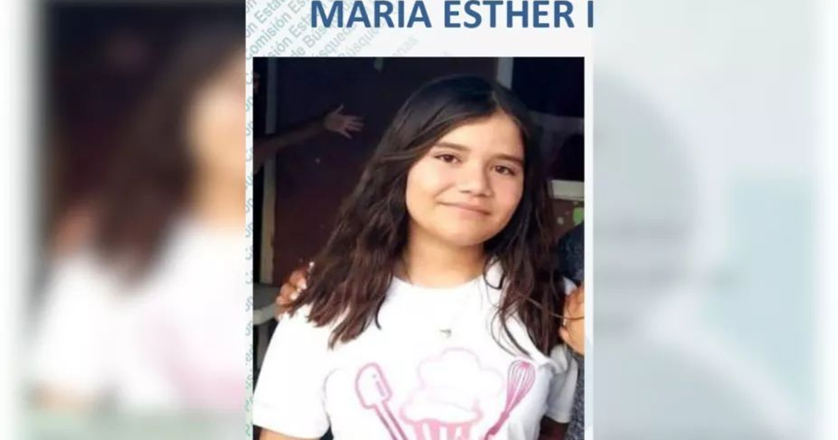 Joven con cabello largo y oscuro, camiseta blanca con diseño de cocina, sonriendo.