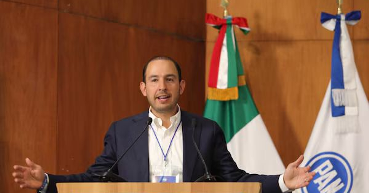 Orador en podio con banderas de México y PAN, hablando sobre elección judicial directa.