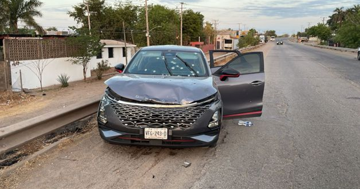 Coche dañado con cofre abollado y parabrisas roto en carretera México 15, tras tiroteo.