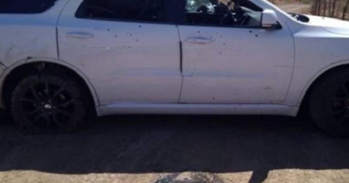 Camioneta blanca con marcas de impacto en terreno de tierra, relacionada con enfrentamiento en Sinaloa.