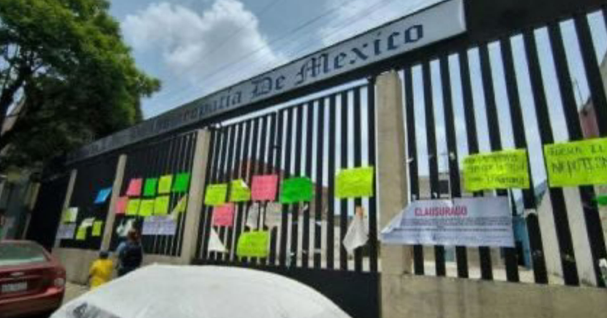 Reja de la Escuela Libre de Homeopatía en Peralvillo con papeles y la palabra 'CLASURADO'.