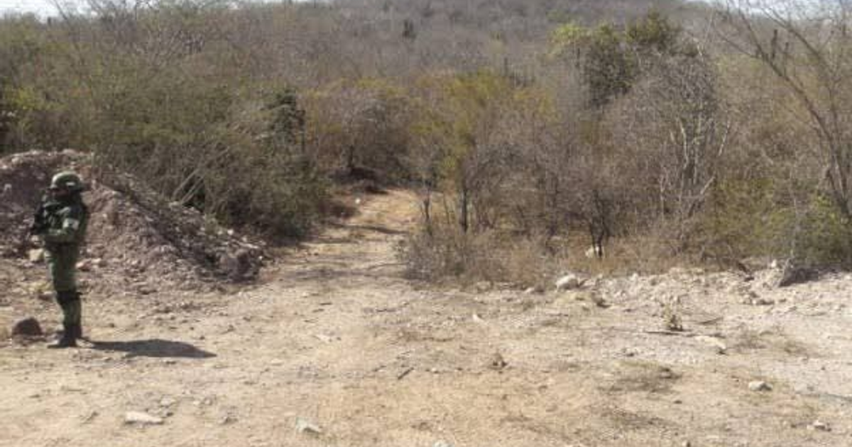 Soldado en paisaje árido con camino de tierra y vegetación seca en Mazatlán, relacionado con fosas clandestinas.