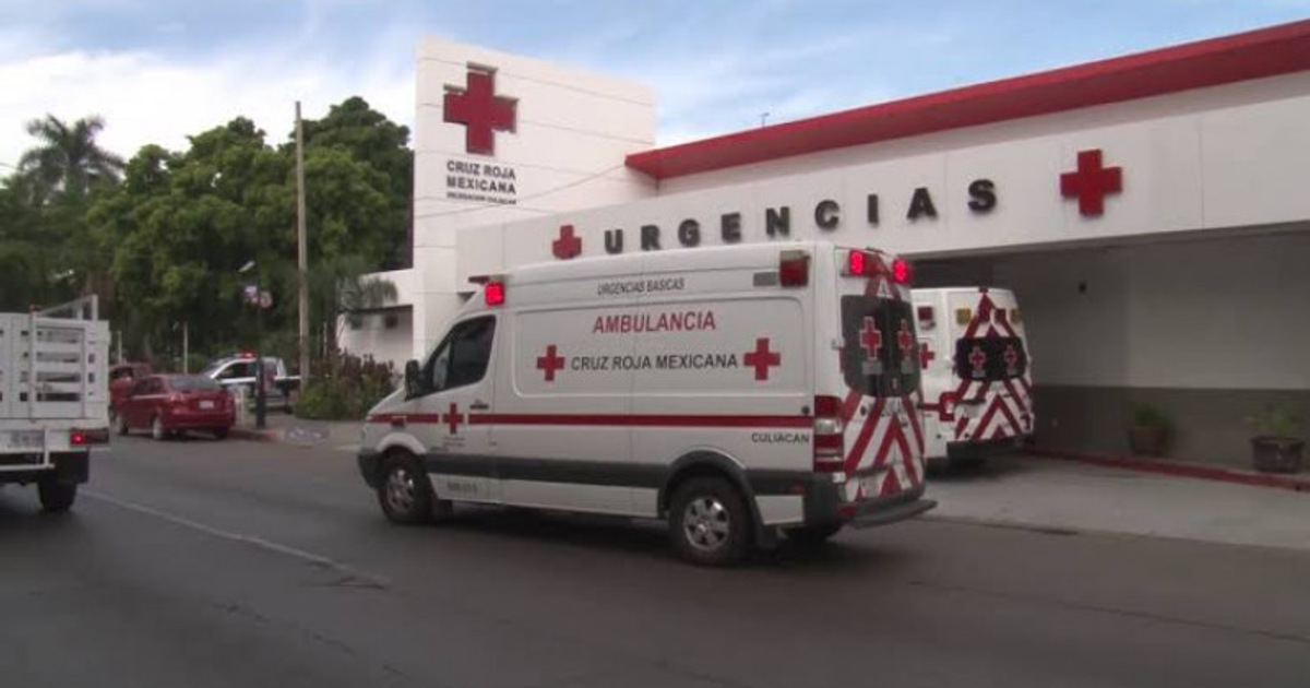 Ambulancias de la Cruz Roja Mexicana estacionadas frente a un edificio con el logo de la Cruz Roja y la palabra 'Urgencias'.