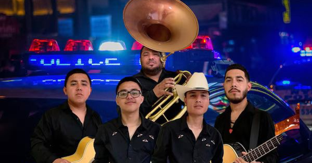 Cinco músicos con instrumentos frente a un vehículo policial en un entorno urbano