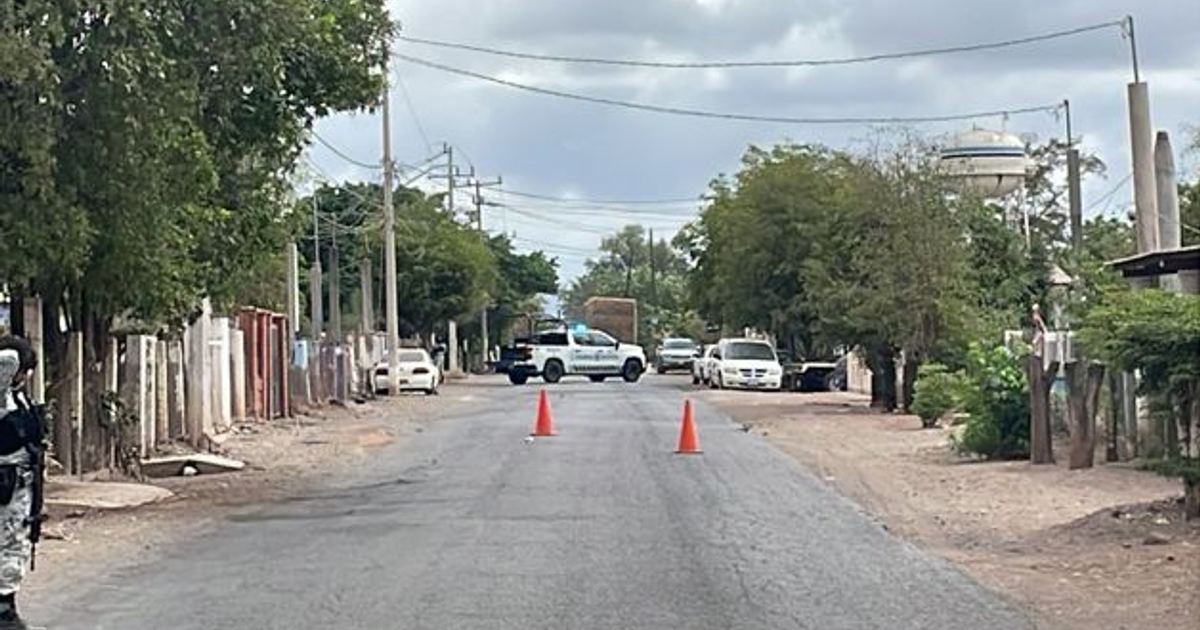 Calle en Culiacán con operativo de la Guardia Nacional, patrulla y policía presentes.