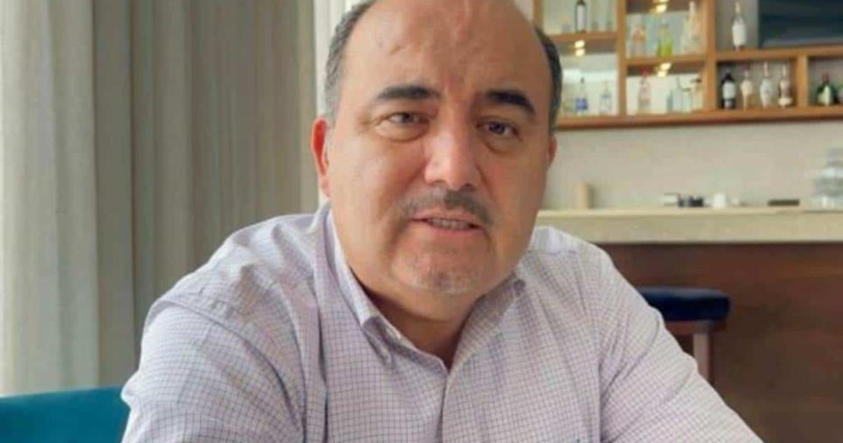 Persona en un café con expresión seria, relacionada con acusaciones financieras.