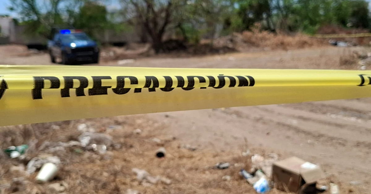 Cinta de precaución amarilla en escena de crimen con vehículo policial en Culiacán