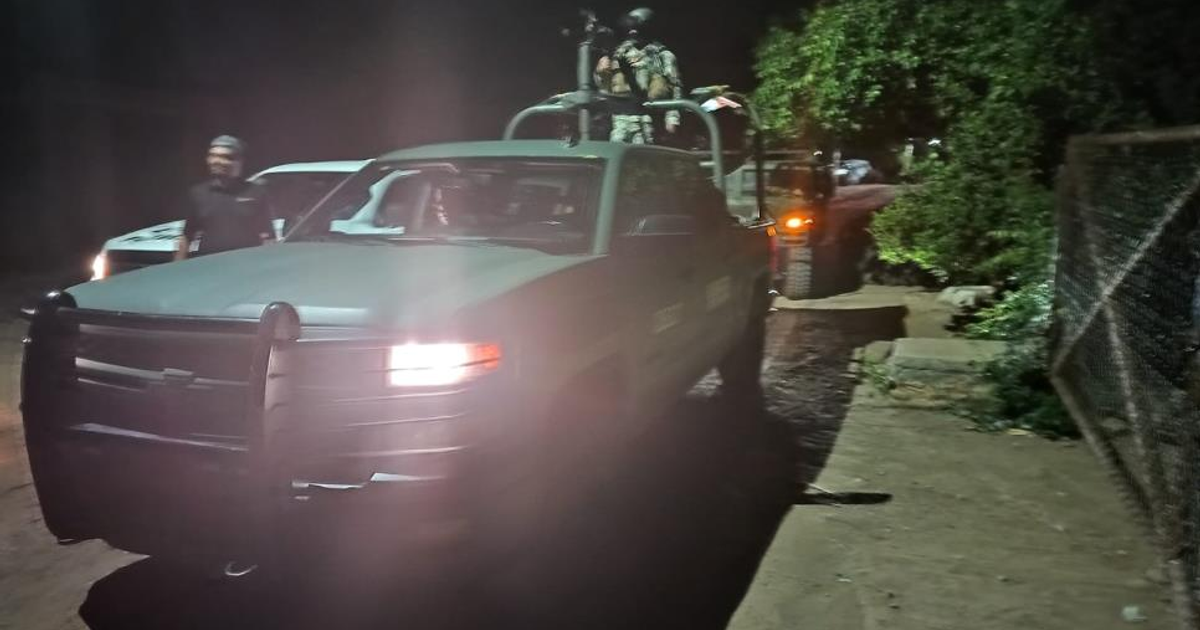 Camioneta verde oscuro en camino de terracería con personal uniformado, escena nocturna en Culiacán.