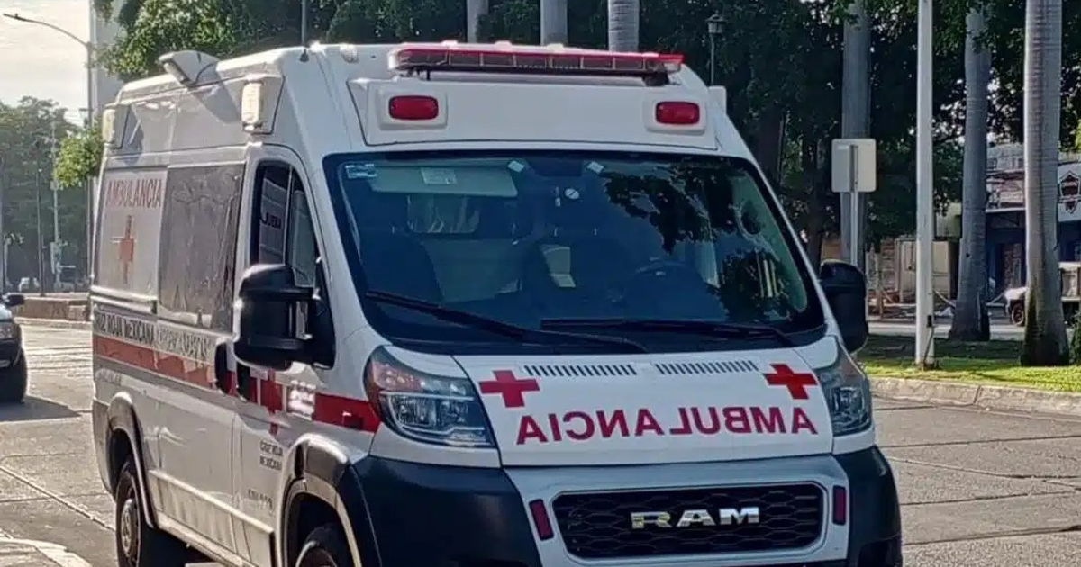 Ambulancia blanca con luces y cruz roja en entorno urbano