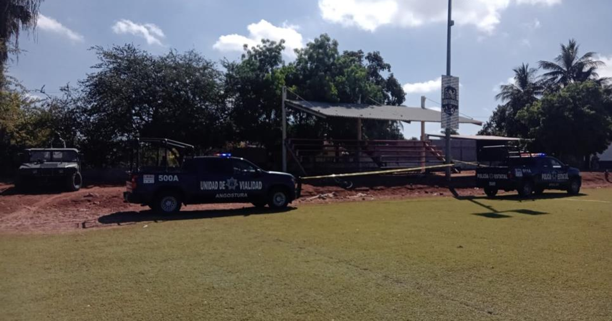 Vehículos policiales en operativo tras hallazgo de cadáver en estadio de fútbol