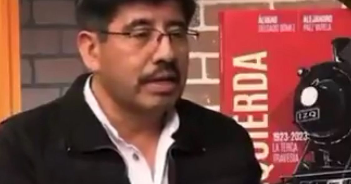 Hugo Aguilar Ortiz hablando en su nombramiento como presidente de la SCJN, con un cartel rojo y una locomotora de fondo.