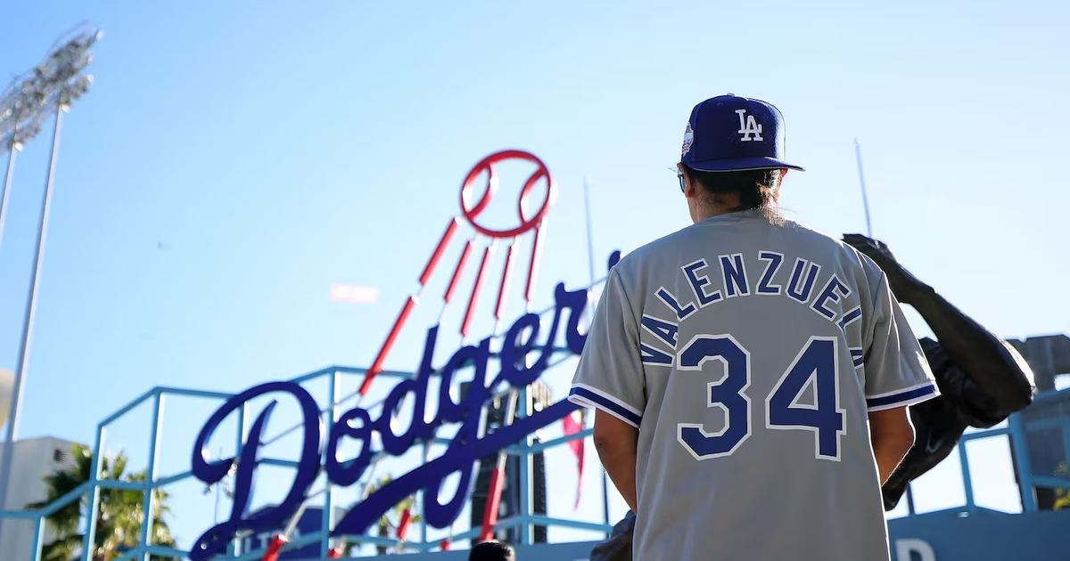 Persona con camiseta de Valenzuela 34 frente a letrero de Dodgers en el estadio