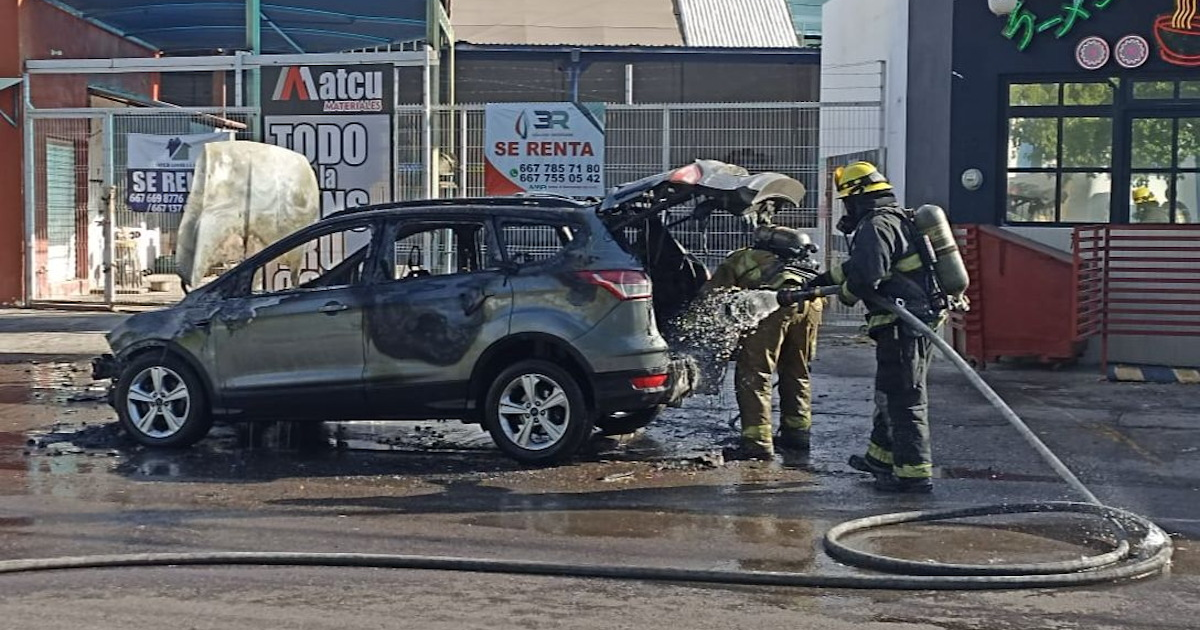 Bomberos apagando incendio en camioneta Ford Escape en Culiacán