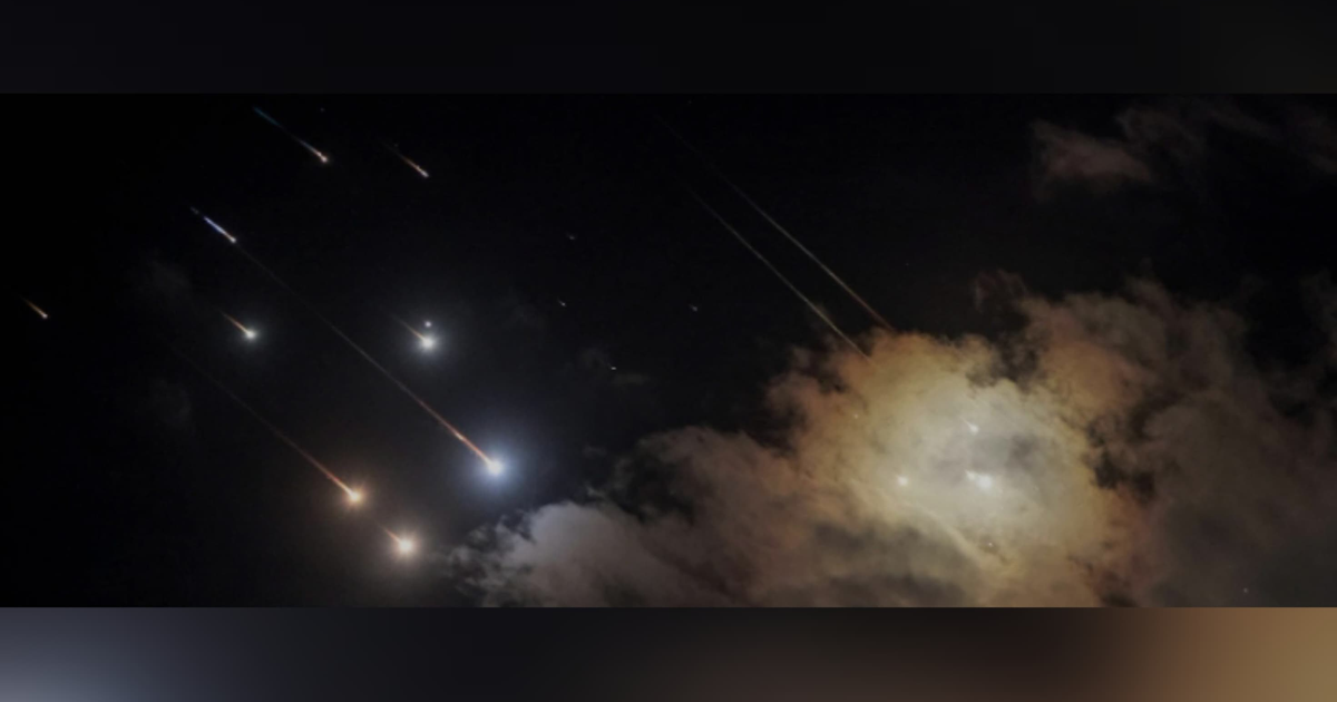 Cielo nocturno con meteoritos y nubes iluminadas, evocando fenómenos astronómicos.