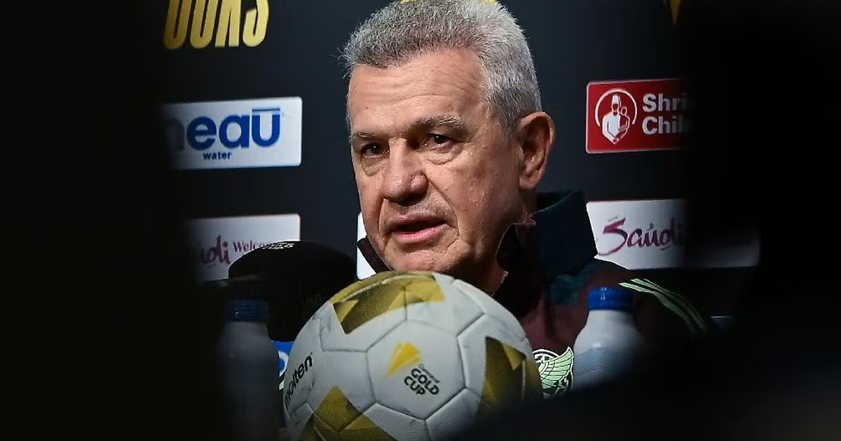 Javier Aguirre en conferencia de prensa sobre la Selección Mexicana, con micrófonos y un balón de fútbol.