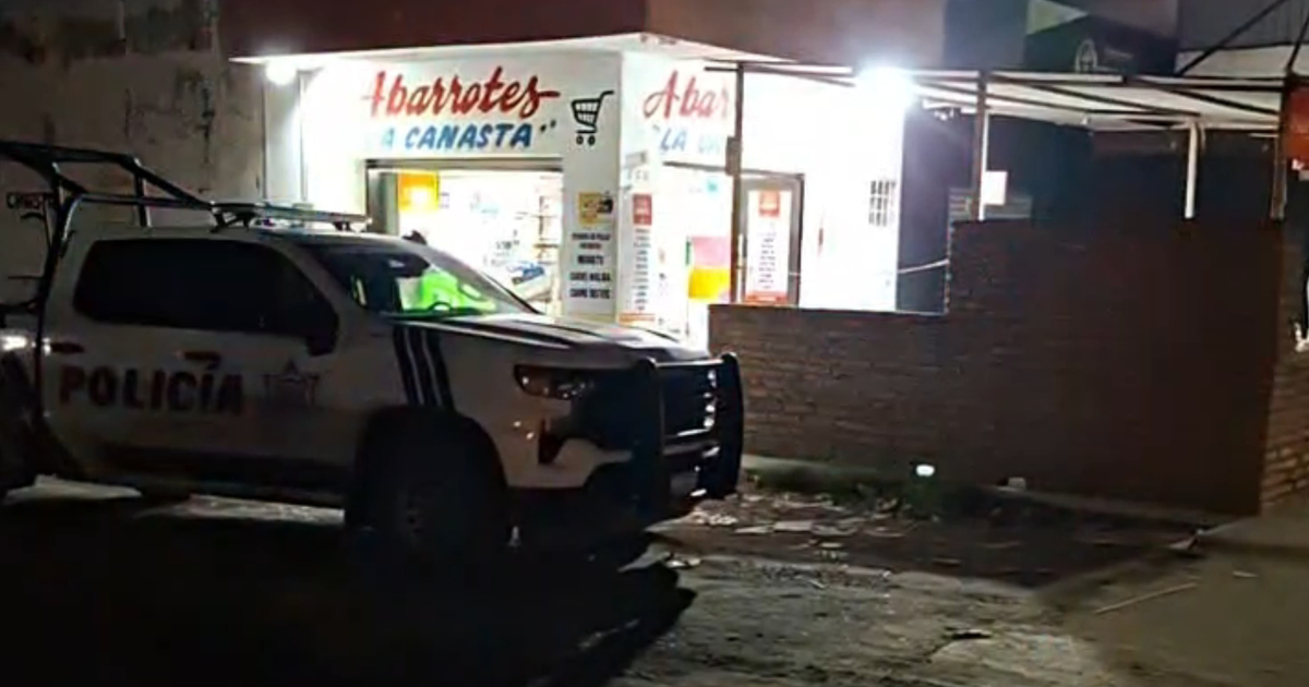 Vehículo de policía estacionado frente a Abarrotes La Canasta en Mazatlán, Sinaloa, de noche.