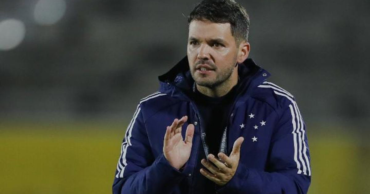 Persona con chaqueta deportiva en campo de entrenamiento, vinculada a Nicolás Larcamón, nuevo entrenador de Cruz Azul.