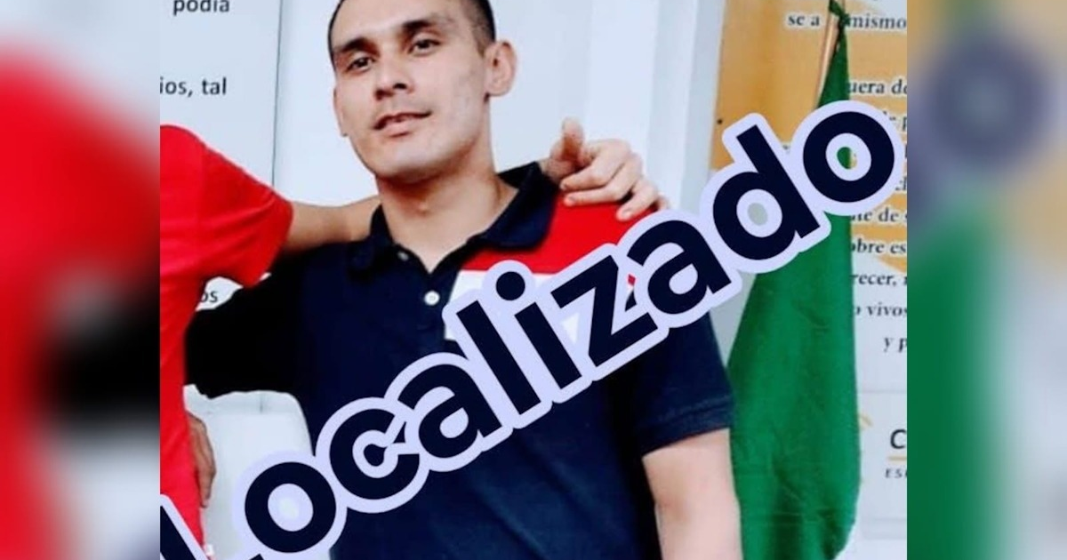 Hombre posando junto a otra persona con texto 'Localizado' y bandera de fondo, relacionado con la localización de un joven desaparecido en El Burrión.