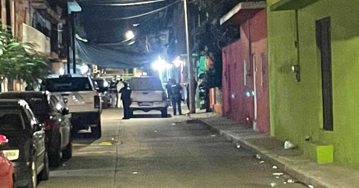 Calle oscura en Guanajuato con vehículos y personas tras masacre