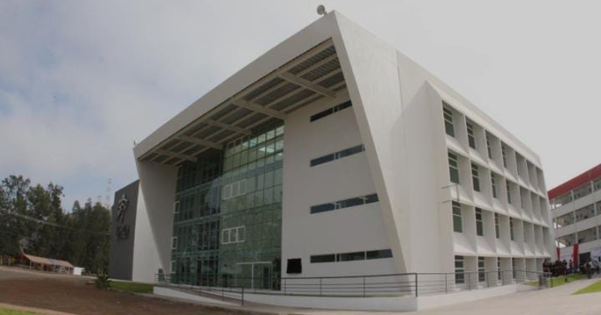 Edificio moderno de la Universidad Autónoma de Occidente en Los Mochis, con fachada de vidrio y blanco, en un día nublado.
