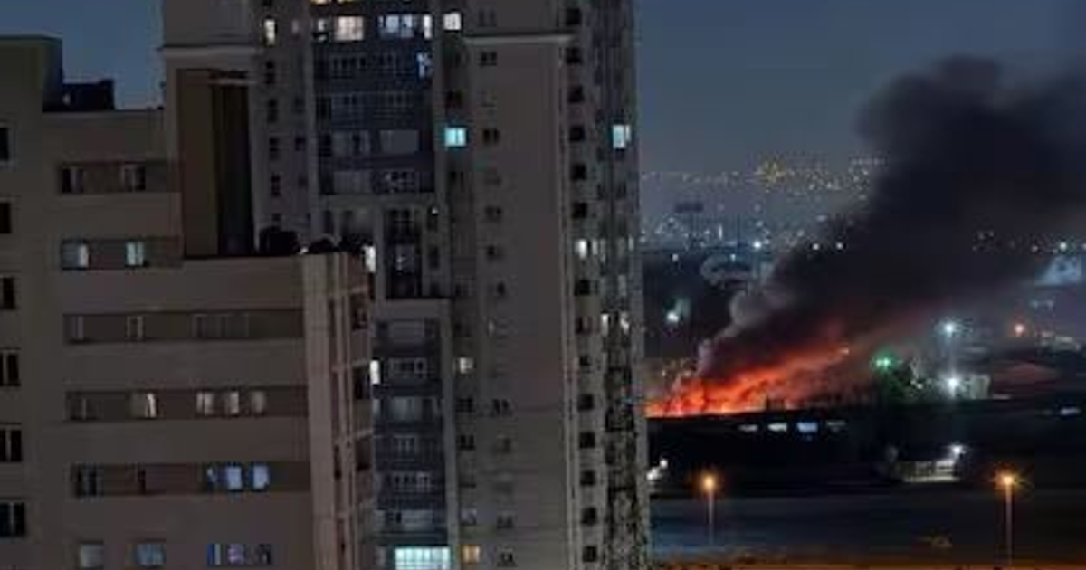 Vista nocturna de ciudad con incendio tras ataque de misiles en Israel