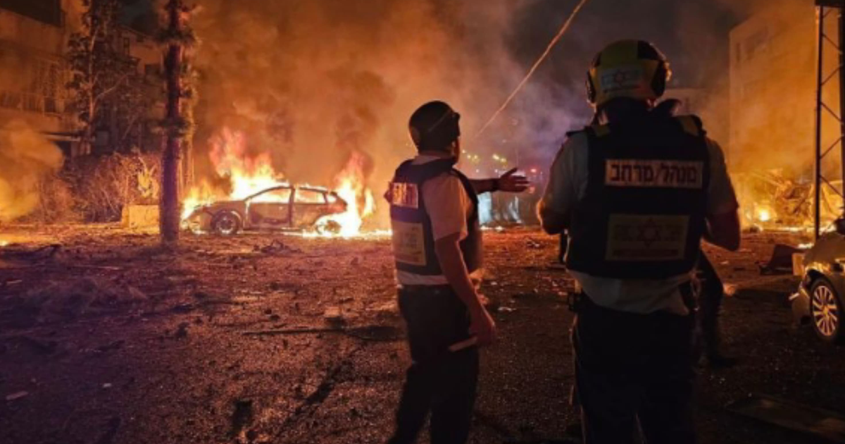 Vehículo en llamas y rescatistas en escena de emergencia en Israel tras impacto de misiles.