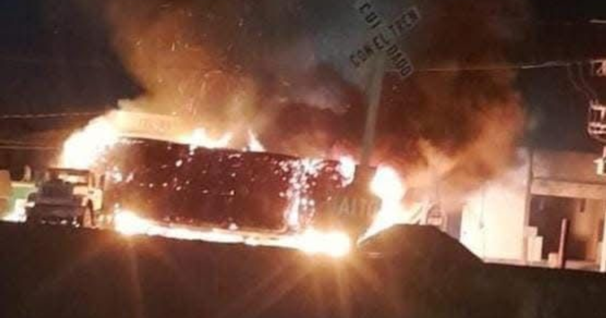 Vehículo en llamas durante narcobloqueo en Sinaloa, México, con humo y llamas visibles en la noche.