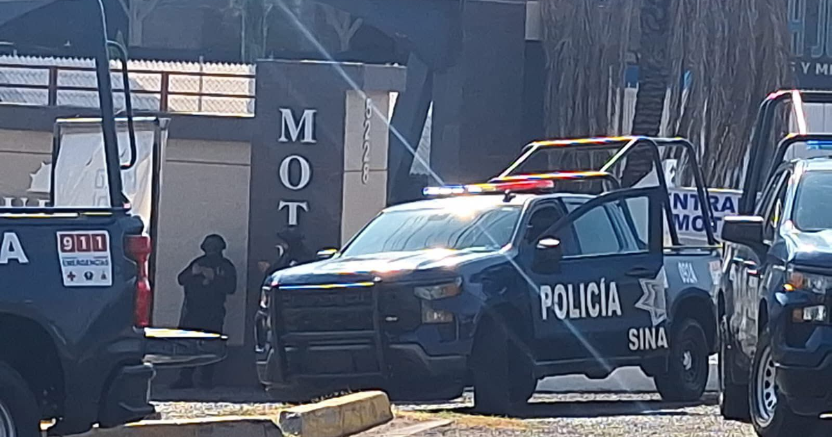 Camionetas de policía con luces intermitentes en un motel durante un operativo en Culiacán.