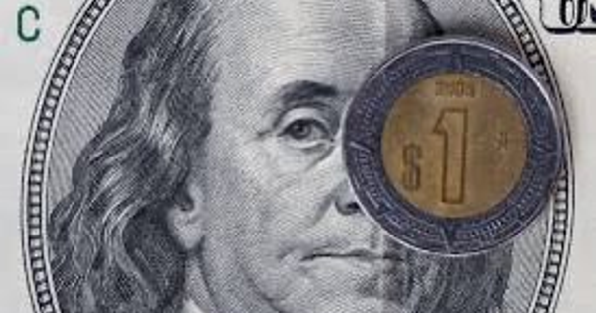 Billete de 100 dólares con moneda de 1 dólar sobre el rostro de Benjamin Franklin.