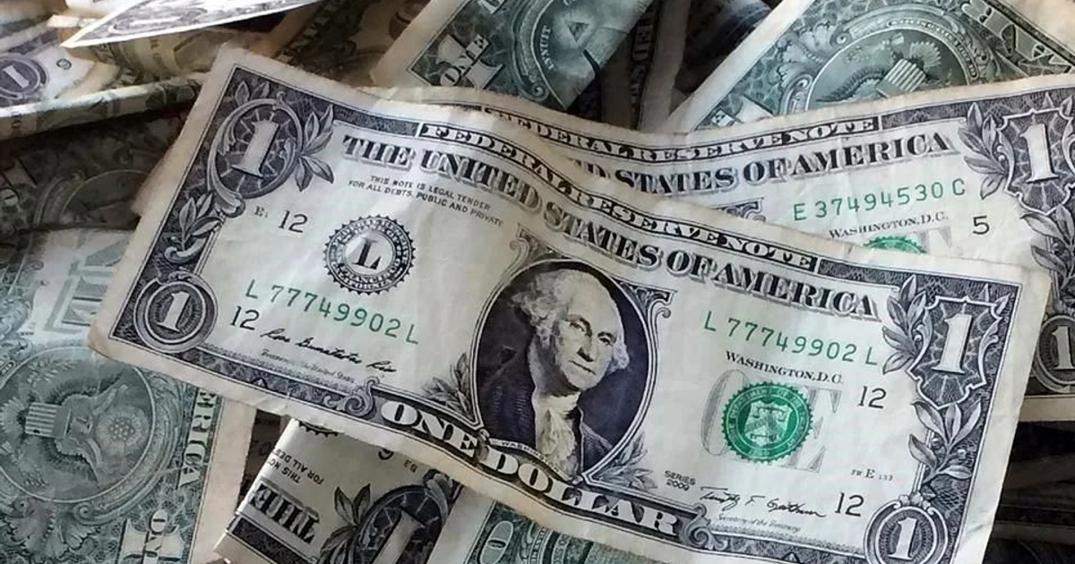 Billetes de un dólar estadounidense apilados, con el rostro de George Washington visible.