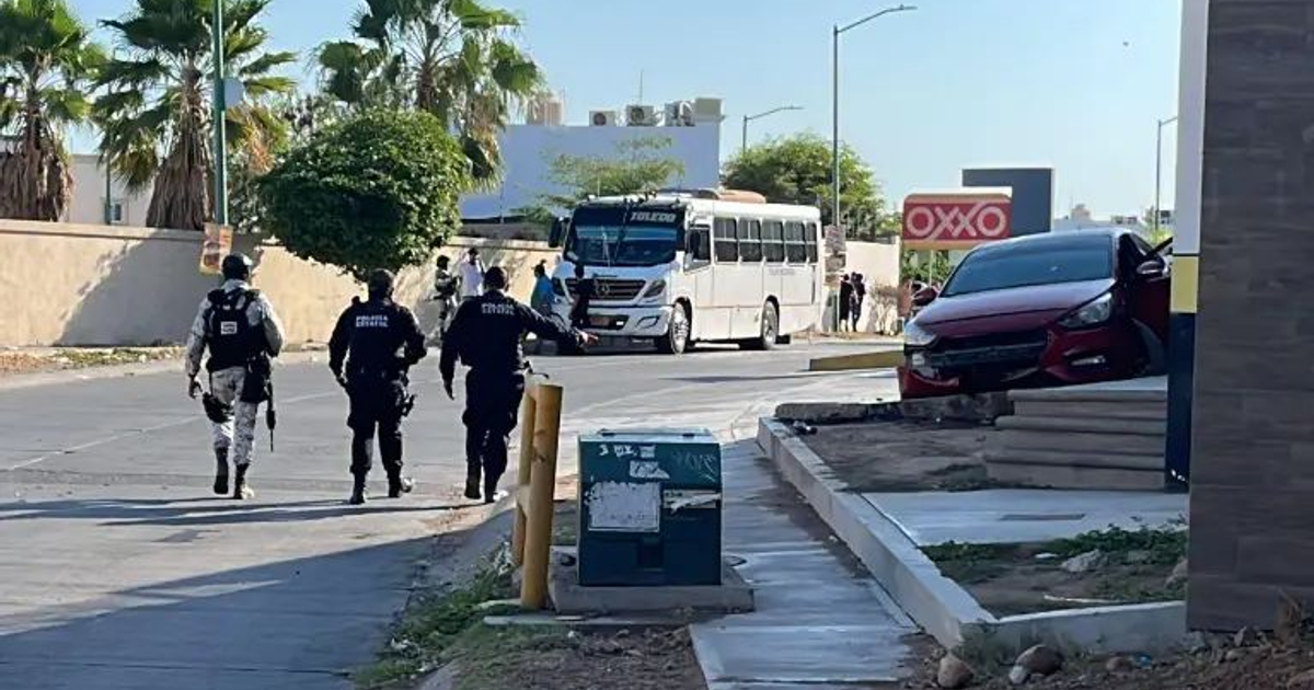 Policías en escena de balacera en Culiacán con autobús blanco y auto rojo