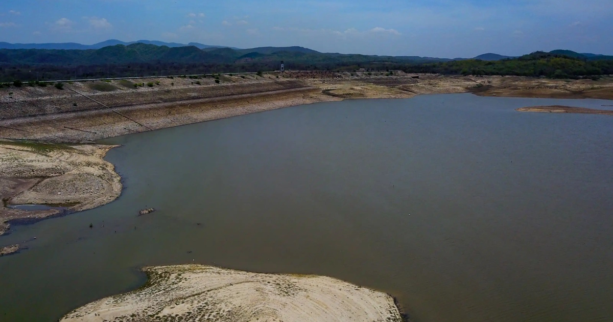 Vista de un embalse en Sinaloa con montañas al fondo y cielo nublado, representando la situación hídrica actual.