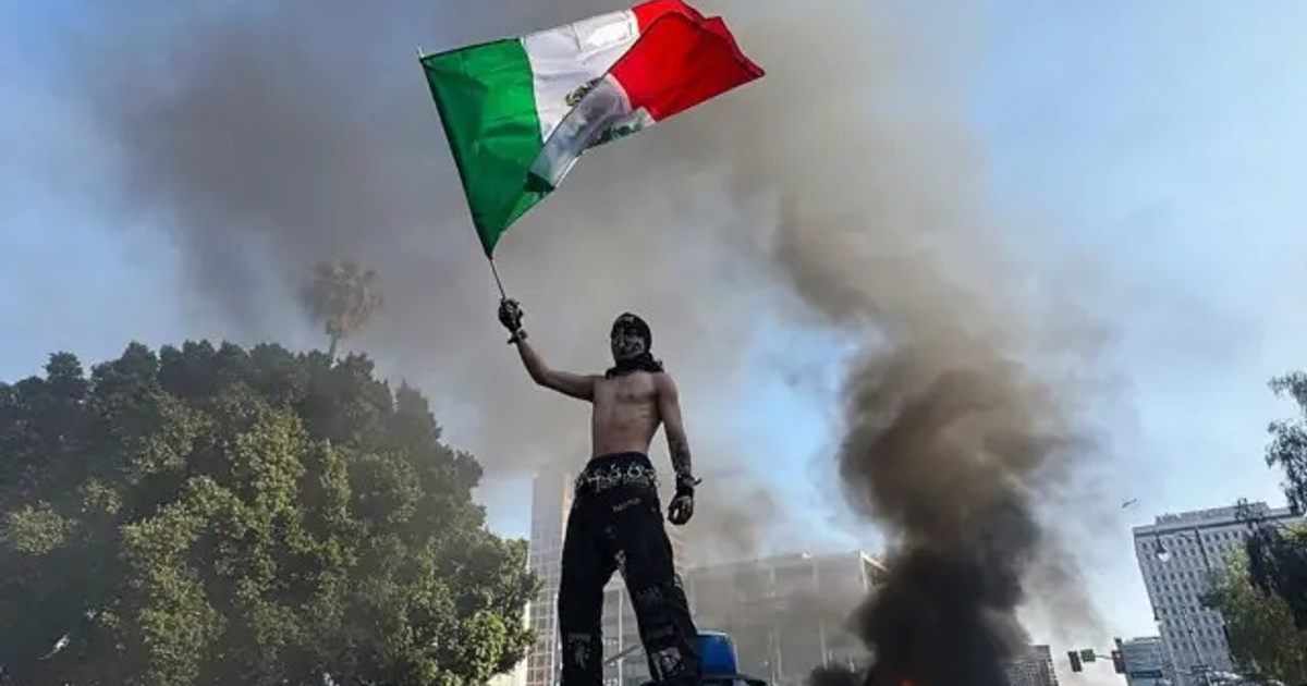Manifestante en Los Ángeles con bandera de México en protesta