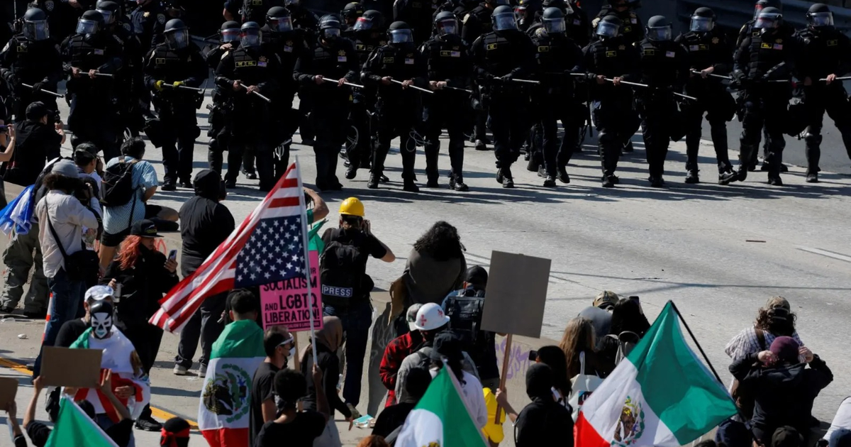 Manifestación con banderas de México y EE.UU. frente a policías en Los Ángeles