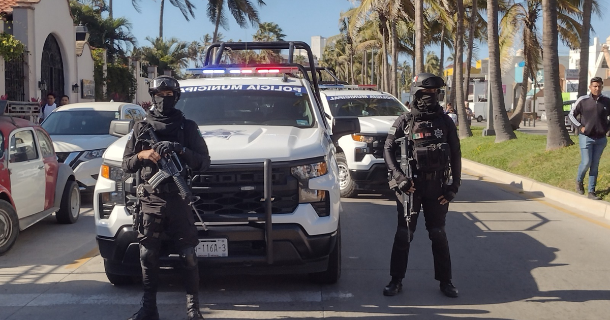 Oficiales de seguridad armados frente a un vehículo policial en un operativo vial en Mazatlán.