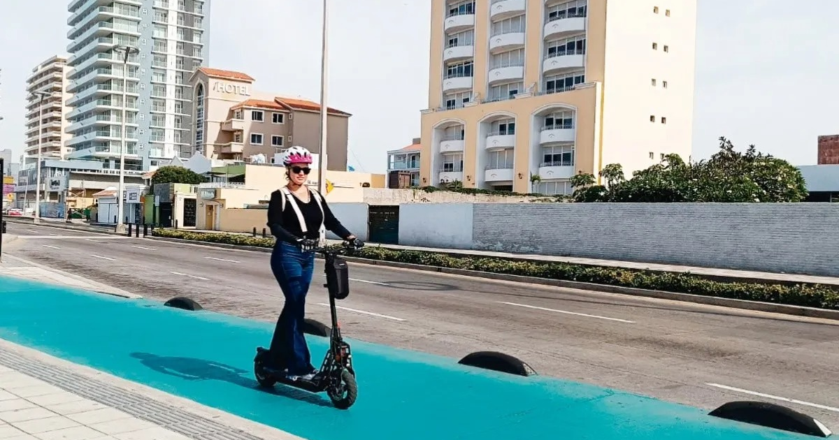 Persona con casco en patinete eléctrico en vía azul, Mazatlán