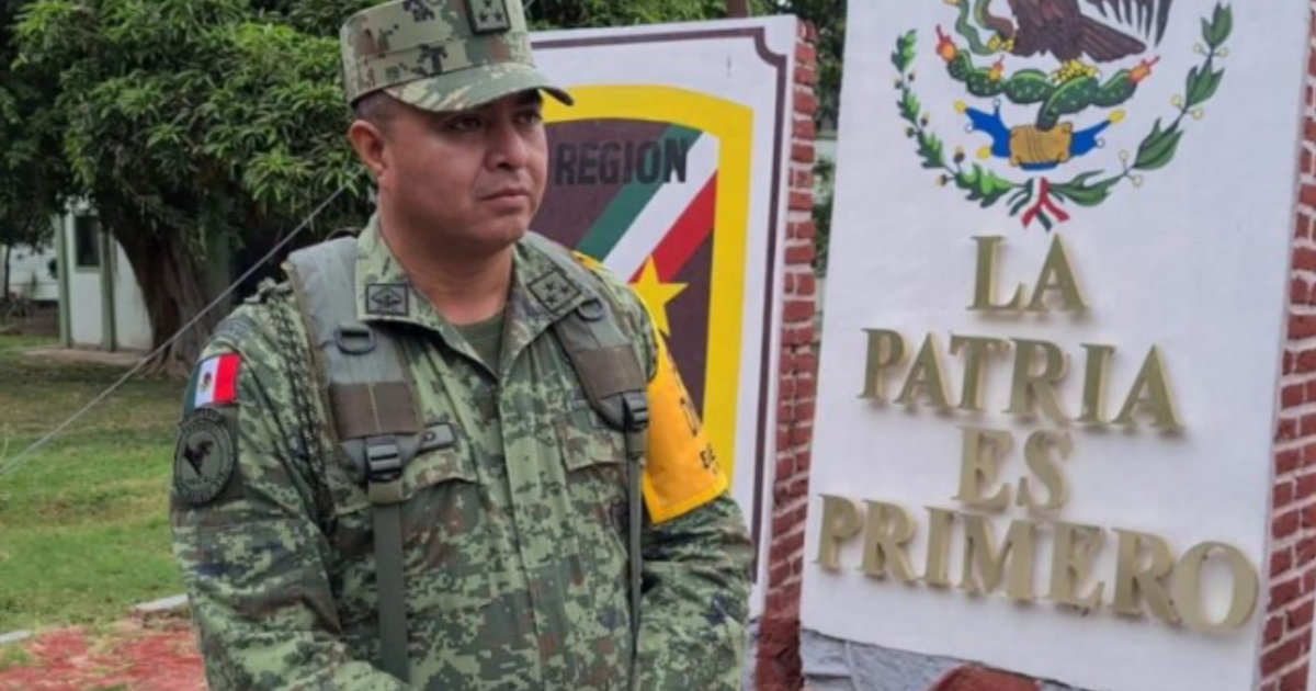 Soldado mexicano en uniforme frente a letrero 'LA PATRIA ES PRIMERO'