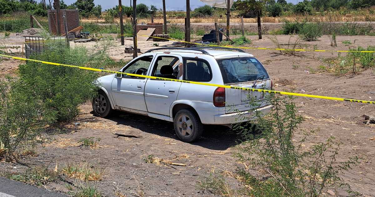 Coche blanco rodeado de cinta amarilla en escena de crimen rural