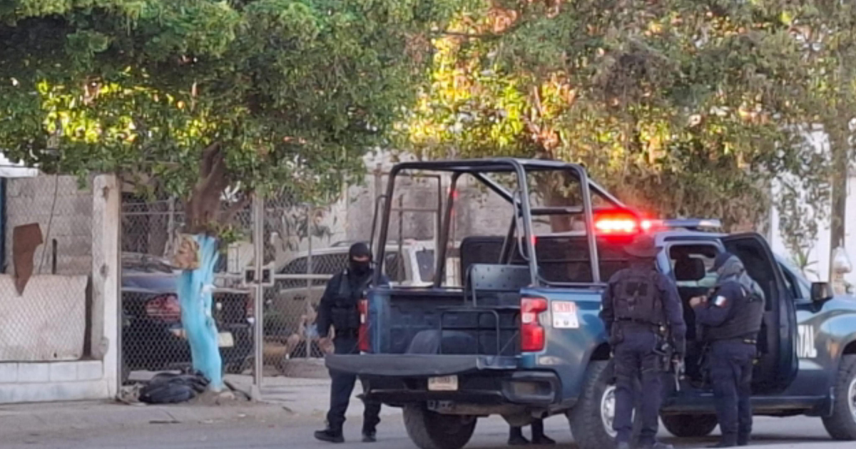 Policías en operativo cerca de camioneta patrulla tras ataque armado en punto de venta de drogas.