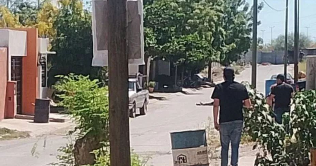 Calle en Culiacán con edificios, vegetación y dos personas caminando de espaldas, relacionada con un ataque armado.