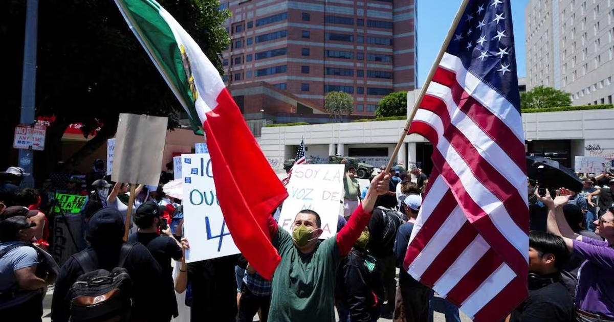 Manifestantes en Los Ángeles con banderas de México y Estados Unidos durante el toque de queda.