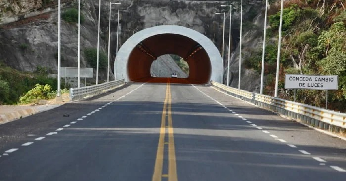 Camino hacia el túnel Cópala I con letrero de 'Conceda cambio de luces' en la supercarretera Durango–Mazatlán.